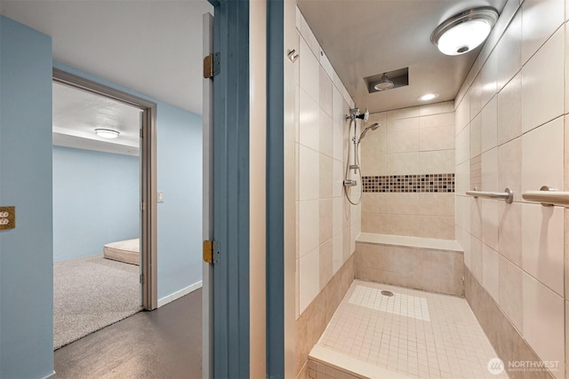 full bath featuring baseboards and tiled shower