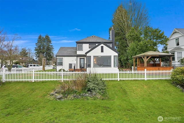 back of property with a gazebo, a lawn, fence private yard, and a chimney