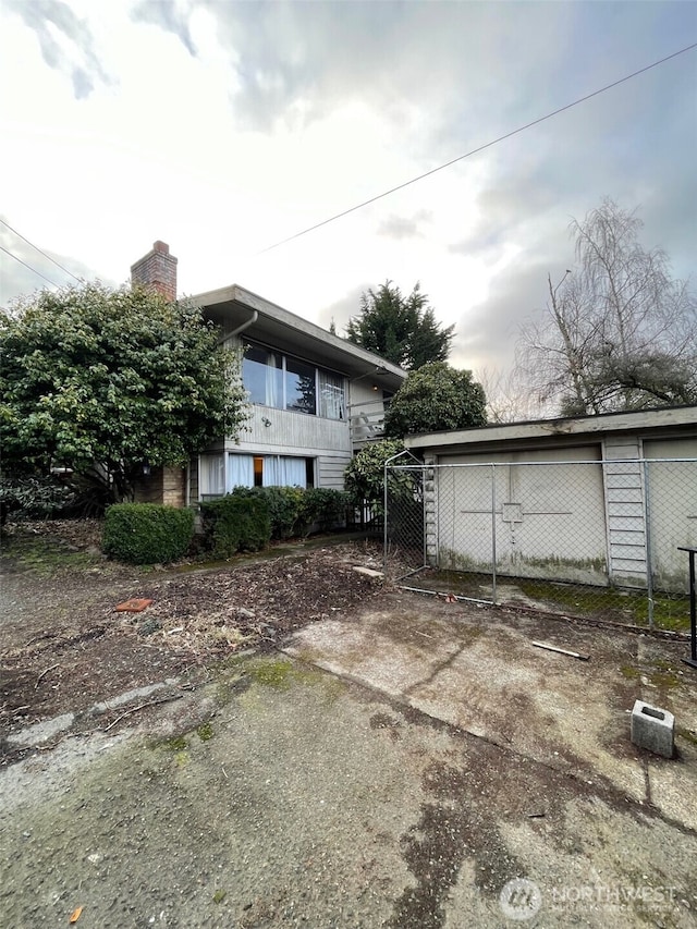11057 Greenwood Ave N, Seattle, WA 98133 - view of side of home with fence and a chimney