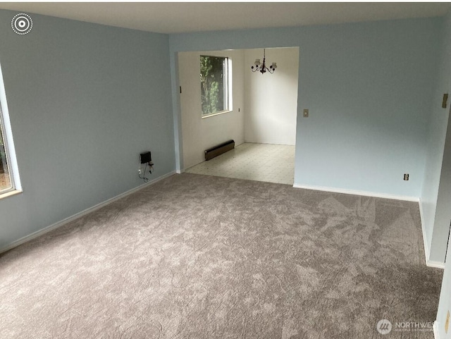 11057 Greenwood Ave N, Seattle, WA 98133 - spare room featuring an inviting chandelier, baseboard heating, and light colored carpet