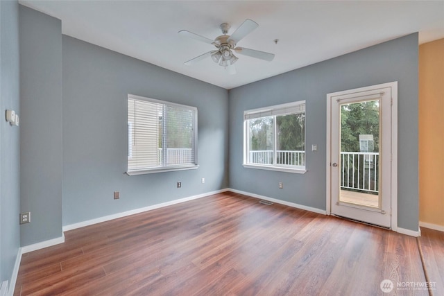 unfurnished room featuring visible vents, ceiling fan, baseboards, and wood finished floors