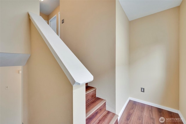 staircase with baseboards and wood finished floors