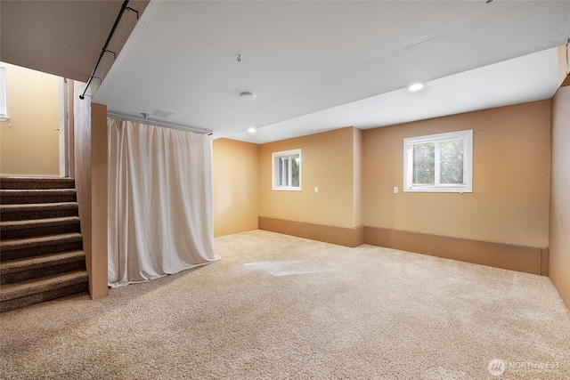 unfurnished room featuring a wealth of natural light, carpet, recessed lighting, and stairs