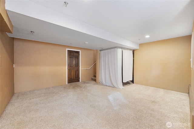 carpeted empty room with stairs and recessed lighting