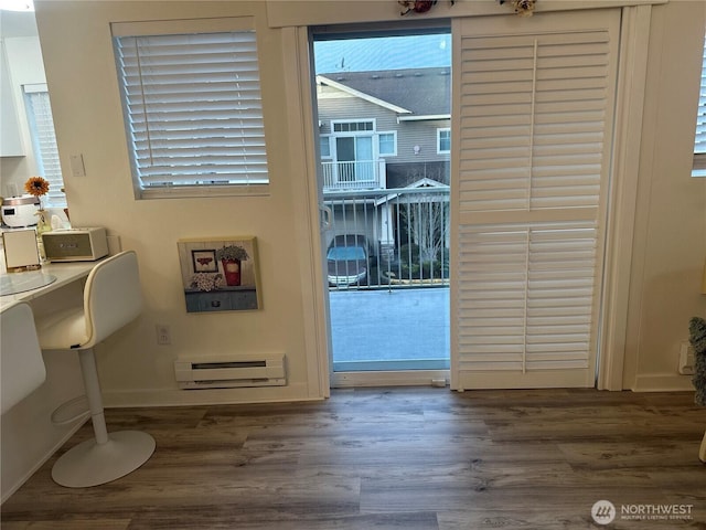 entryway featuring baseboards, baseboard heating, and wood finished floors