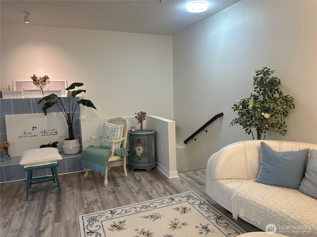 sitting room with an upstairs landing and wood finished floors