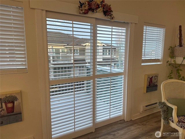 interior details with baseboard heating and wood finished floors