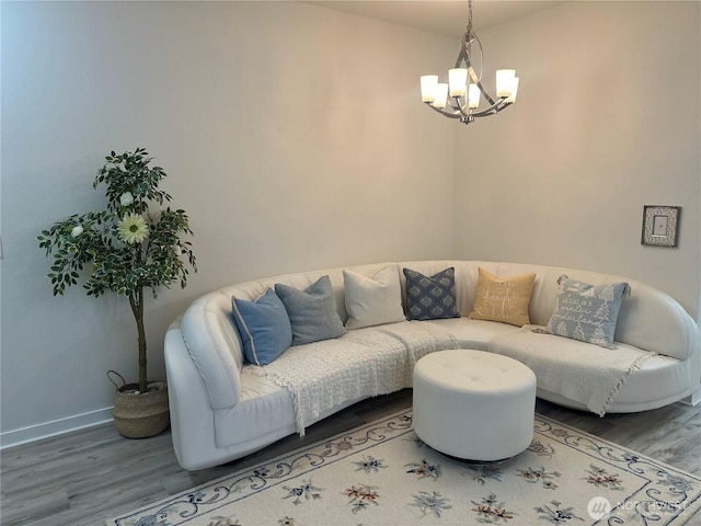 living area featuring an inviting chandelier, wood finished floors, and baseboards