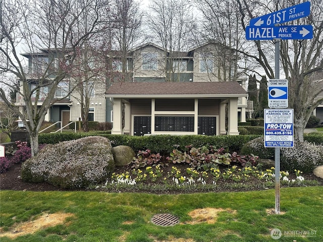 view of front of property featuring a front yard and roof with shingles