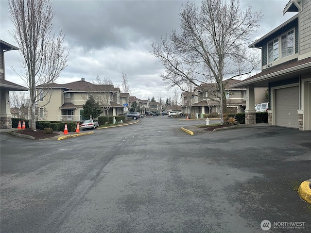 view of road featuring a residential view and curbs