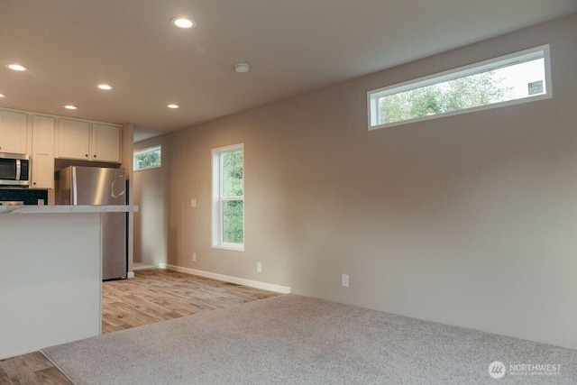 kitchen featuring light countertops, a healthy amount of sunlight, white cabinetry, and stainless steel appliances