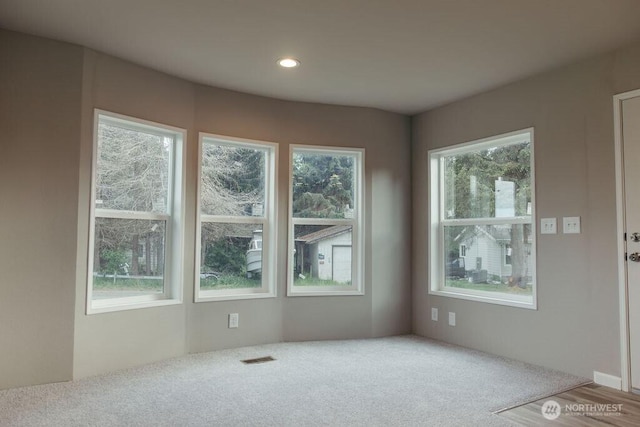 empty room featuring carpet floors, visible vents, and recessed lighting