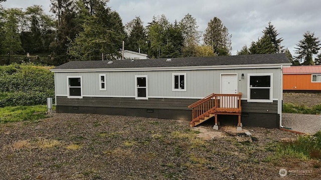 rear view of property featuring a shingled roof and crawl space