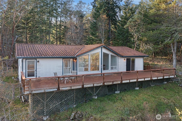 rear view of house with a tiled roof and a wooden deck