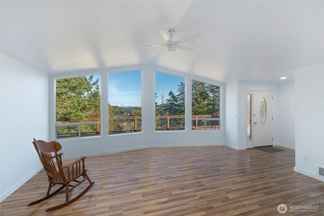 unfurnished sunroom featuring lofted ceiling, visible vents, and a ceiling fan