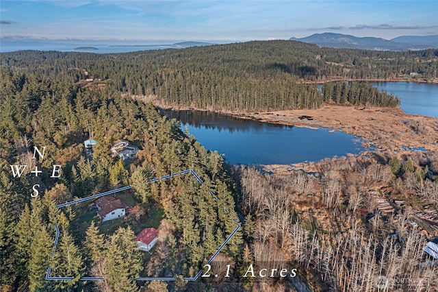 birds eye view of property with a wooded view and a water and mountain view