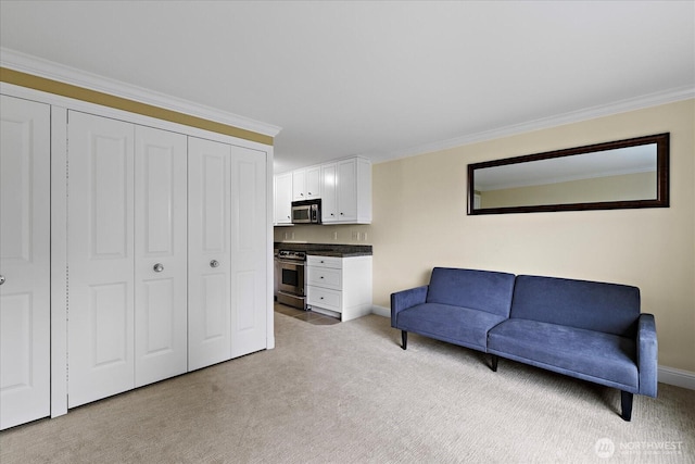 sitting room with light colored carpet, crown molding, and baseboards