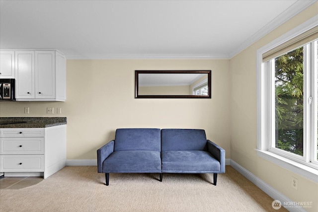 sitting room featuring baseboards, ornamental molding, and light colored carpet