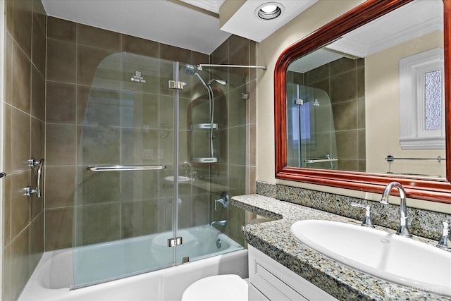 full bath with toilet, bath / shower combo with glass door, crown molding, and vanity