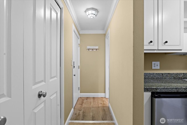 corridor with baseboards, light wood-style floors, and crown molding