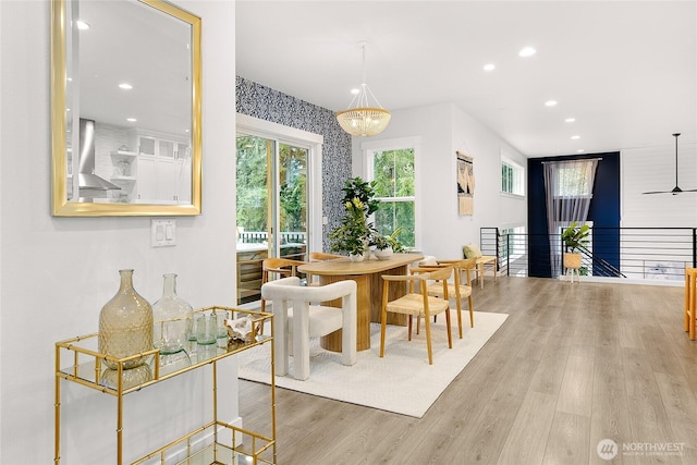 dining area with light wood-style flooring, ceiling fan with notable chandelier, and recessed lighting