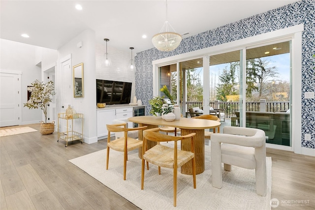 dining area featuring light wood-style floors, recessed lighting, baseboards, and an inviting chandelier