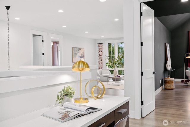 interior space featuring light wood-type flooring, baseboards, light countertops, and recessed lighting