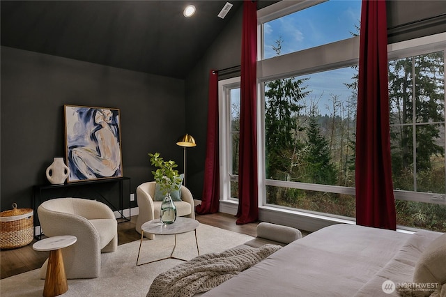 interior space with vaulted ceiling, wood finished floors, and visible vents