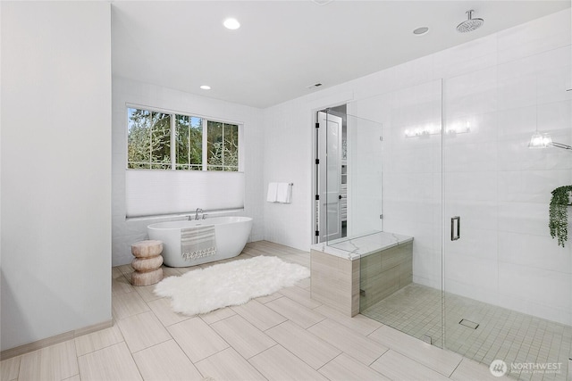 full bathroom with a soaking tub, a shower stall, and recessed lighting