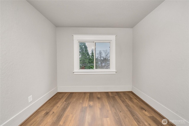 empty room featuring baseboards and wood finished floors