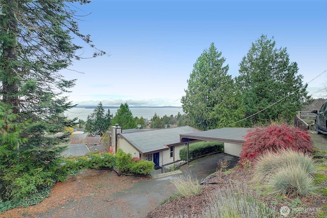 view of front of property with a carport, a water view, and driveway