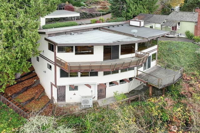 rear view of house featuring ac unit and stucco siding