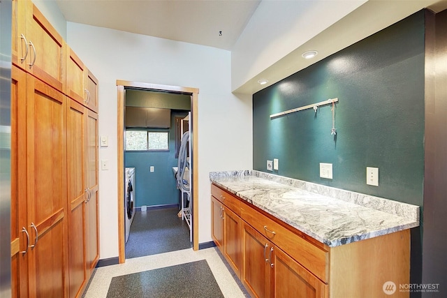 interior space featuring washer and dryer, vanity, and baseboards