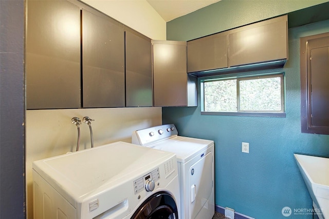 laundry area with cabinet space, a textured wall, and independent washer and dryer