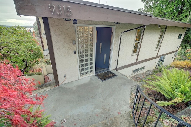 doorway to property featuring stucco siding