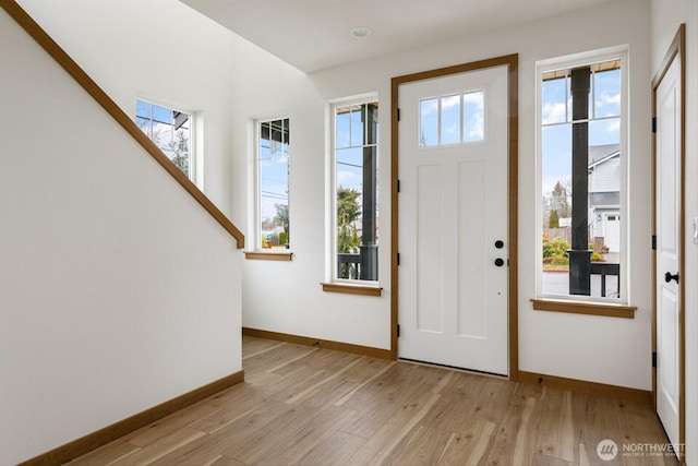 entryway with baseboards and light wood finished floors