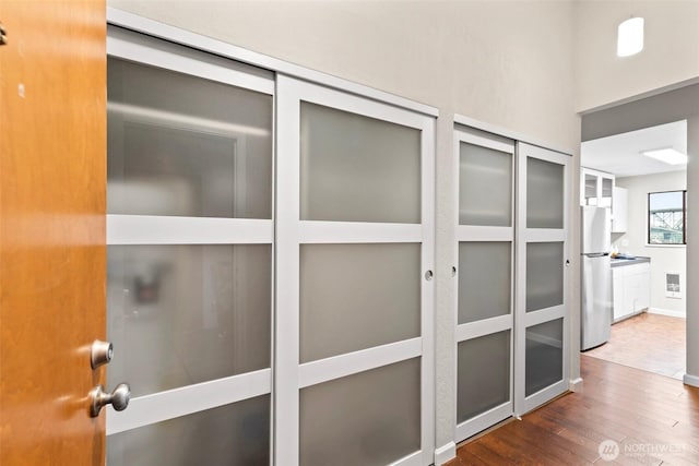 room details featuring visible vents, wood finished floors, freestanding refrigerator, and baseboards