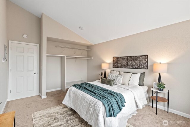 bedroom featuring vaulted ceiling, a closet, carpet, and baseboards