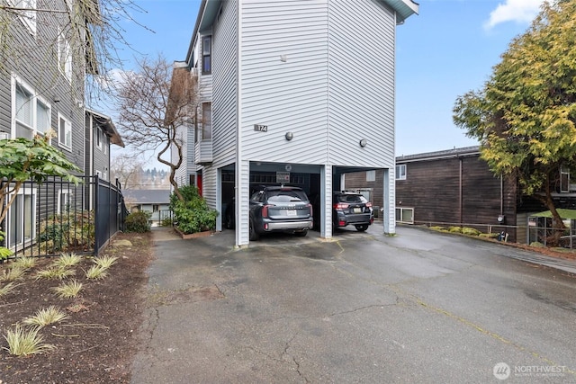 view of property exterior with a carport and driveway