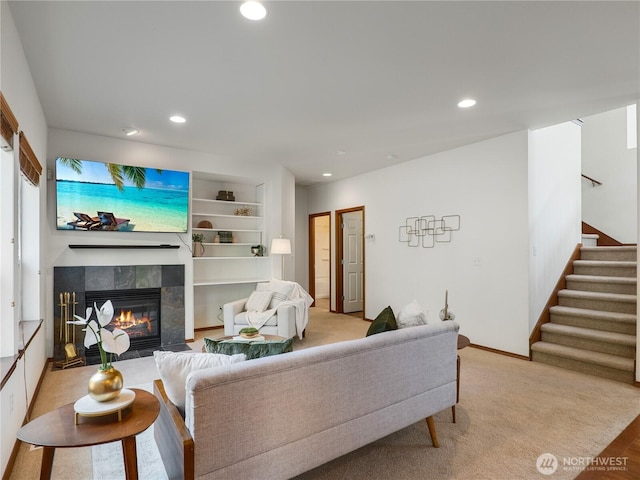 living area featuring built in shelves, stairway, a fireplace, and recessed lighting