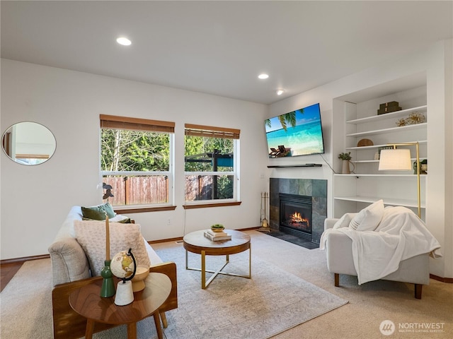 living area featuring built in features, recessed lighting, baseboards, and a tiled fireplace