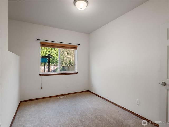 carpeted empty room with visible vents and baseboards