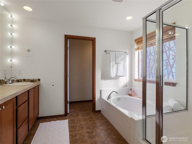 bathroom featuring baseboards, tile patterned floors, a garden tub, vanity, and a shower stall