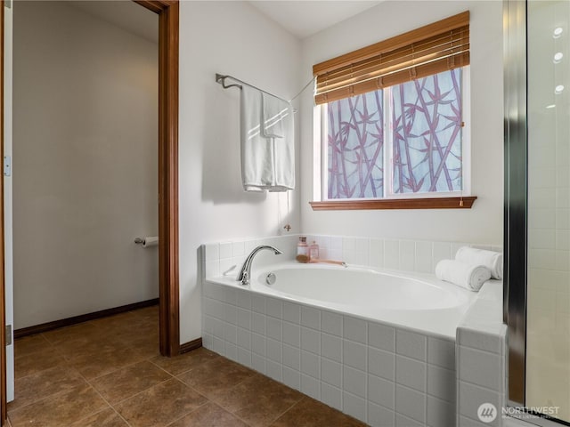 bathroom with tile patterned flooring, a garden tub, and baseboards