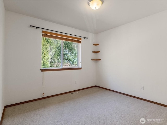 spare room with carpet, visible vents, and baseboards