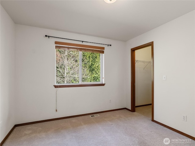 empty room with light carpet, visible vents, and baseboards