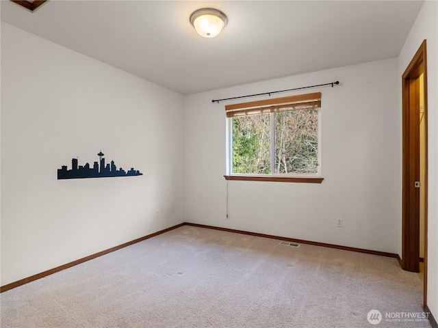 carpeted spare room featuring baseboards and visible vents