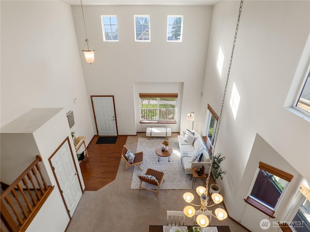 living room with a high ceiling, stairway, and wood finished floors