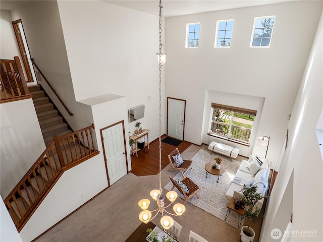 living room featuring carpet flooring, stairway, and a high ceiling