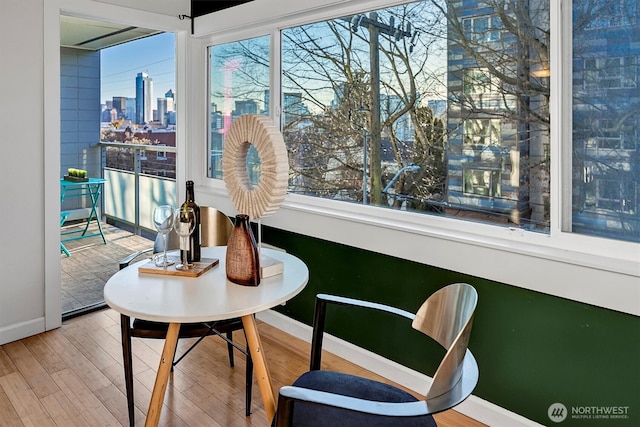 dining space featuring a view of city, baseboards, and wood finished floors